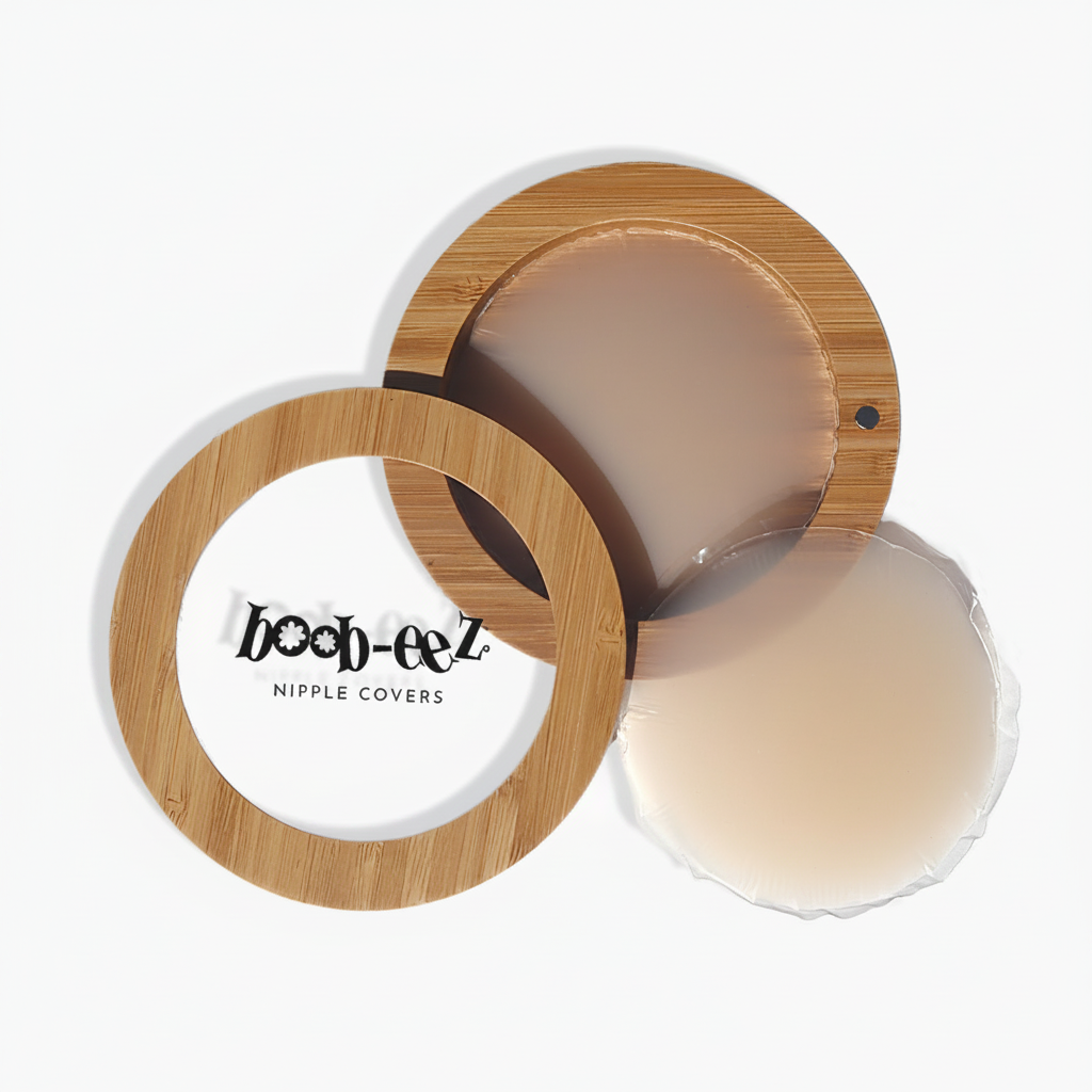 Product shot of Boob-eez Bamboo Compact with 8cm Light tint Headlight Hiders inside and informative insert cards with wear and care instructions, close-up shot showing how to open and close the Bamboo Compact