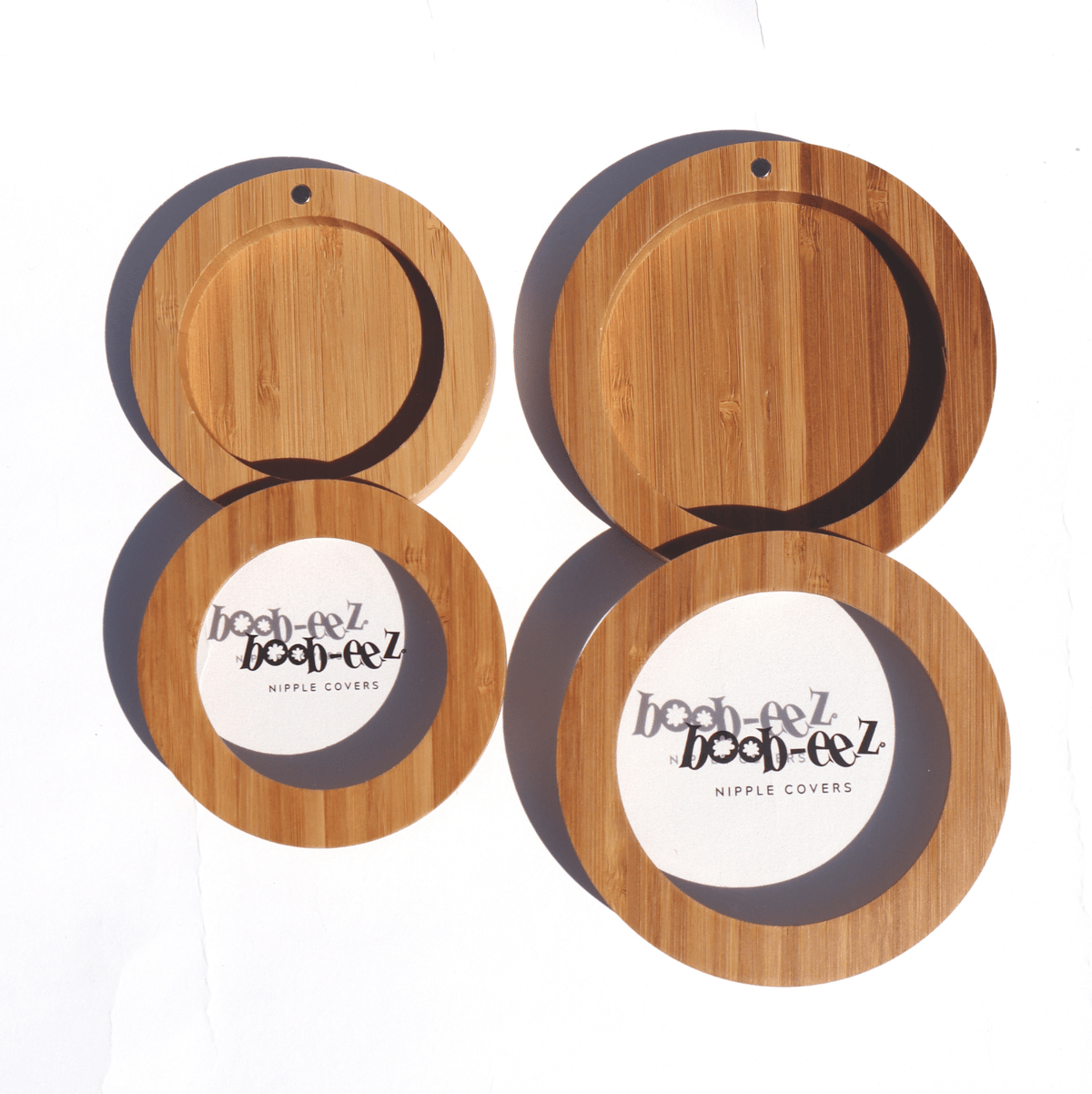 Product shot of the Boob-eez Bamboo Compact Cases size 6cm and 8cm, comparing the size difference, close-up front shot showing the size options for the 6cm and 8cm Headlight Hiders to be stored inside
